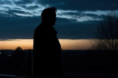 Un Hombre Se Para Frente A Una Puesta De Sol Con La Puesta De Sol