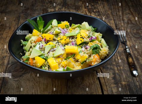 Schüssel mit Quinoa Salat mit Mango Avocado Tomaten Gurken Kräutern