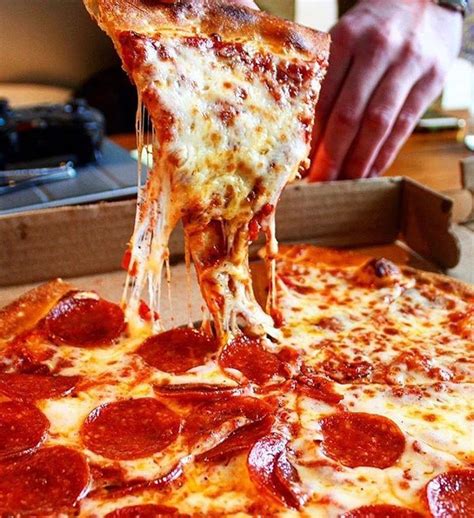 A Slice Of Pepperoni Pizza Being Lifted From A Box