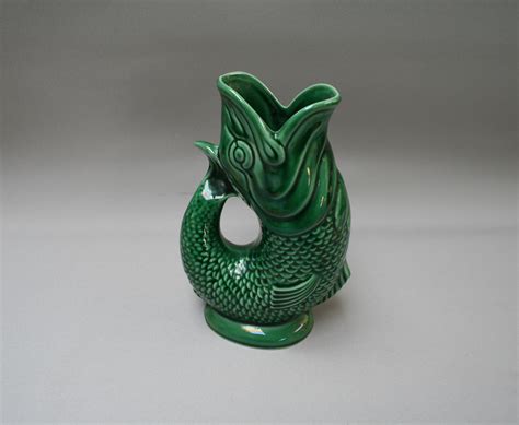 A Dartmouth pottery gurgle fish jug in a green glaze.