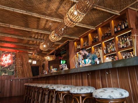 A Bar With Stools And Bottles On The Shelves