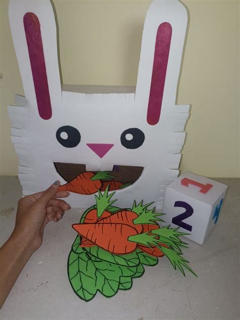 A Paper Bunny With Carrots On The Ground Next To It S Number Two