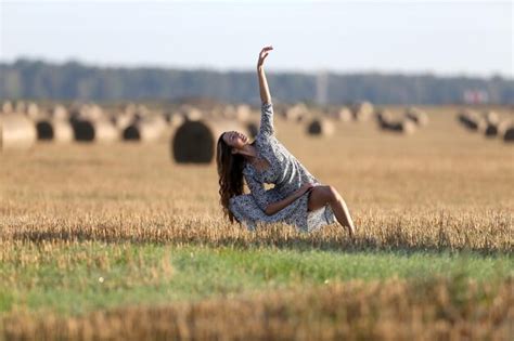 Premium Photo Portrait Of Young Woman Sitting On Grassy Field