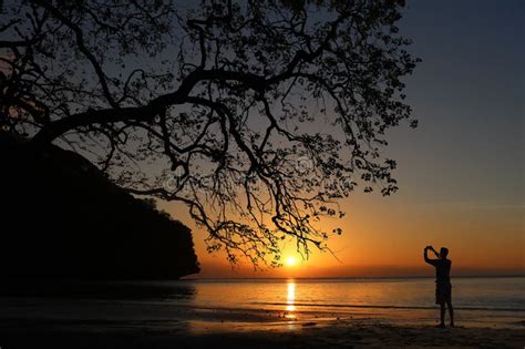 Man Taking Picture Of Sunset Beautiful Red Sky With The Shadow Of A