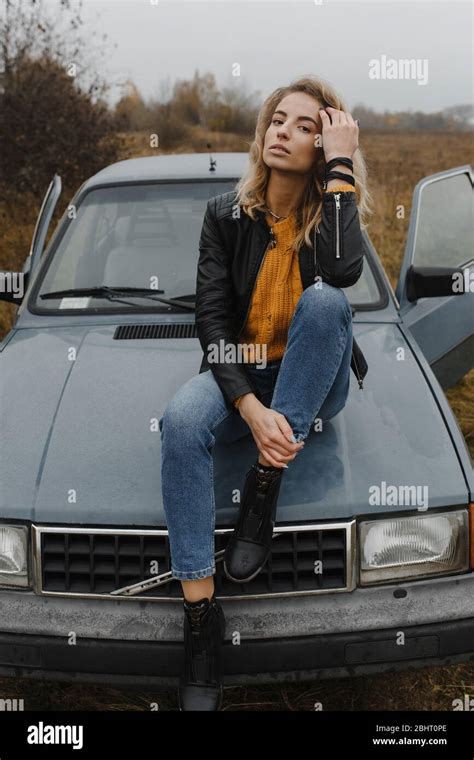 Blonde Woman Sitting On The Car Hood Stock Photo Alamy