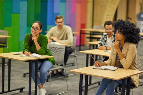 Premium Photo Group Of Young Multiracial People Sitting At Desks In