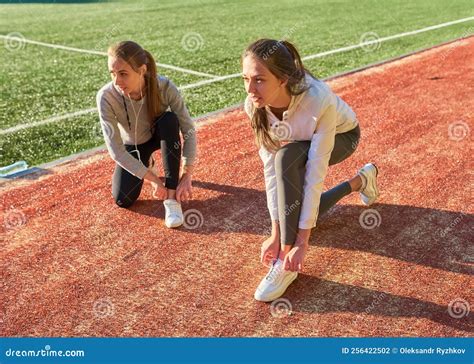 Twee Meisjes In Sportkleding Die In Het Stadion Van Twee Sportvriendinnen Poseren Stock Foto