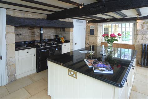 Cotswold Cottage Kitchen With Black Countertops And White Cabinets