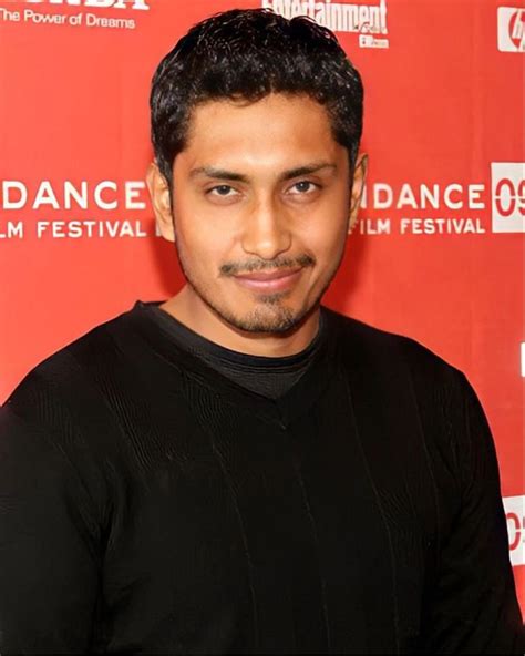 A Man In Black Shirt Standing Next To A Red Wall