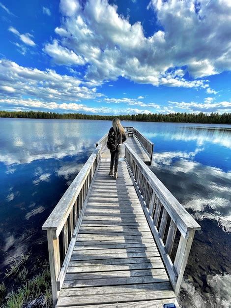 Premium Photo Rear View Of Man Standing On Pier Over Lake Against Sky