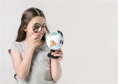 Fille Regardant Le Globe Avec La Loupe Photo Gratuite