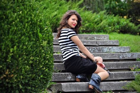 Menina Bonita Que Senta Se Em Escadas No Parque Foto De Stock Imagem