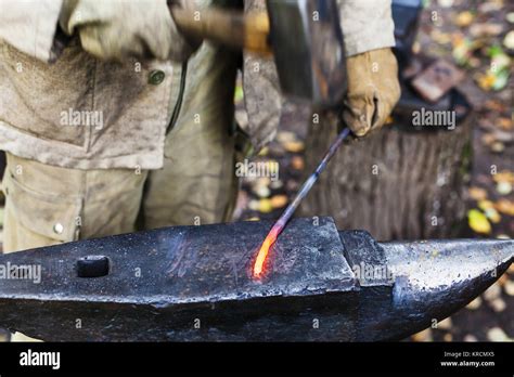 Blacksmith Hammering Red Hot Iron Rod On Anvil Stock Photo Alamy