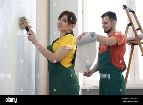 Workers Hanging Stylish Gray Wallpaper In Room Stock Photo Alamy