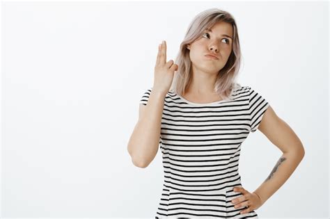 Portrait de jeune fille blonde mécontente qui pose en studio Photo Gratuite