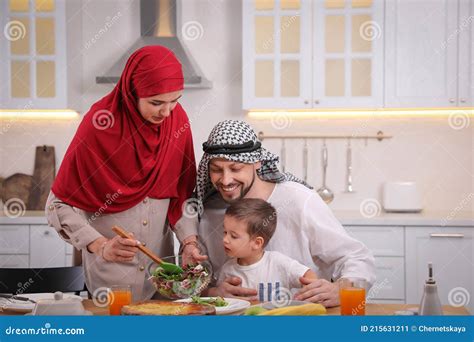 Familia Musulmana Feliz Comiendo Juntos En La Cocina Imagen De Archivo