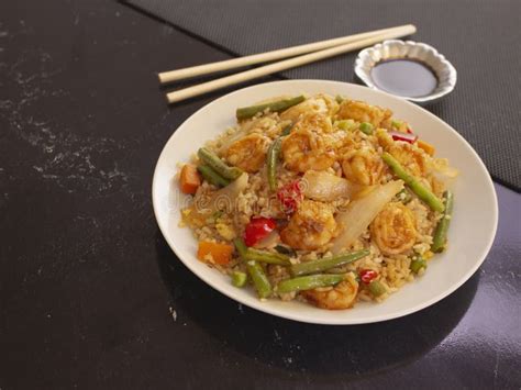 Shrimps With Rice And Vegetables Cantonese Style On A White Plate With