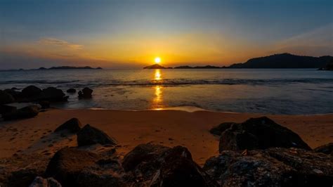 Una Playa Al Atardecer Con El Sol Poni Ndose Detr S Foto Premium