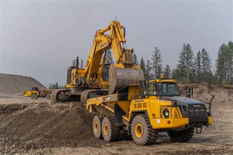 A Komatsu Pc1250 Excavator Loads Ore Into A Komatsu Hm400 Dump Truck