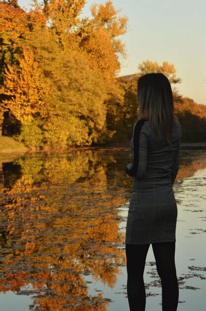 Premium Photo Rear View Of Woman Standing At Lakeshore During Autumn