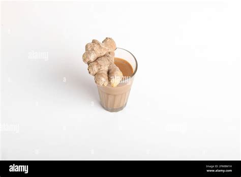 Glass Cup Of Hot Ginger Tea With Ginger Rhizome Root Sliced Isolated On White Background Stock
