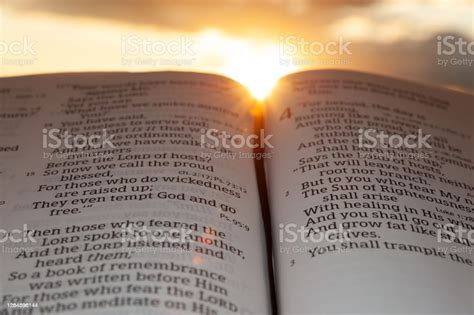 Holy Bible Open At Sunset With Highlight On Malachi 42 Background With Clouds And Sun Stock