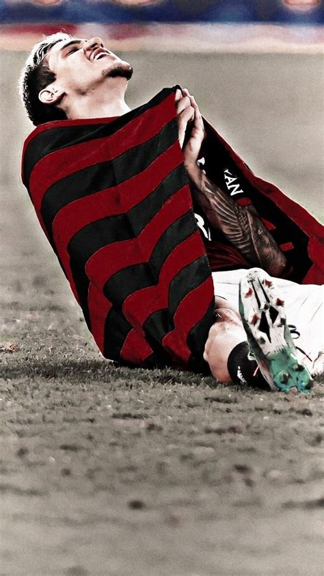 A Man Laying On The Ground Wearing A Red And Black Striped Shirt With