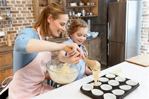 Mother And Daughter Putting Dough In Form For Baking Cookies Stock