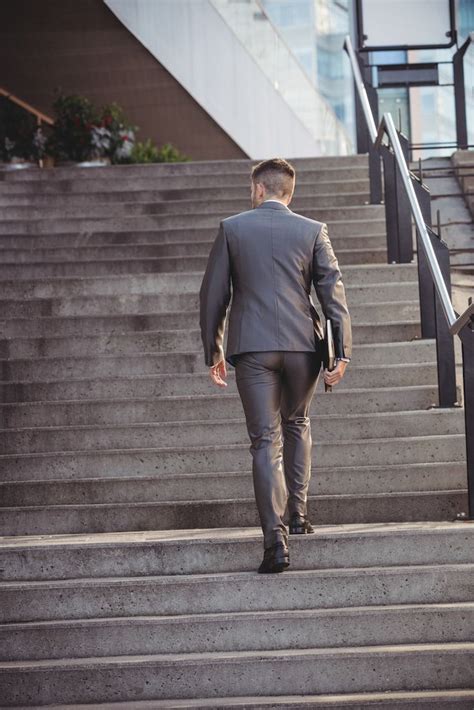 Free Photo Businessman With A Diary Climbs Up Stairs Walking Poses