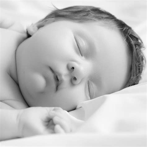 Small Baby Girl Sleeping Newborn Baby In A Wrap On White Blanket Stock