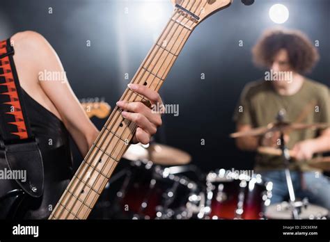 Close Up View Of Female Musician Playing Electric Guitar With Blurred