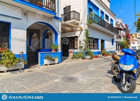 Street With Colourful Houses And Scooters Parked On Side In Kokkari