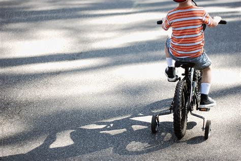 "Child Rides Bike With Training Wheels On Bike Path" by Stocksy ...