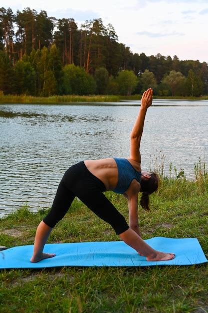 Une Femme Tire Ses Muscles Sur Le Lac Dans La Nature Notion D