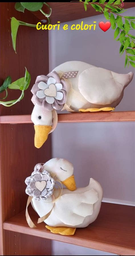 Two White Ducks With Flowers On Their Heads Are Sitting On The Shelves