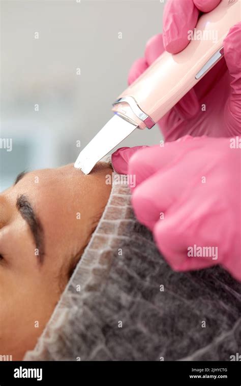 Cosmetologist Beautician In Pink Gloves Making Facial Treatment With