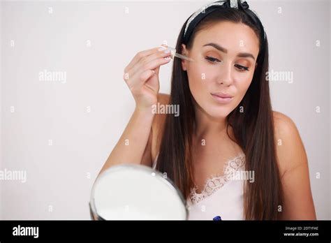 Girl Applies Serum To Face Brunette In Nightgown Stock Photo Alamy