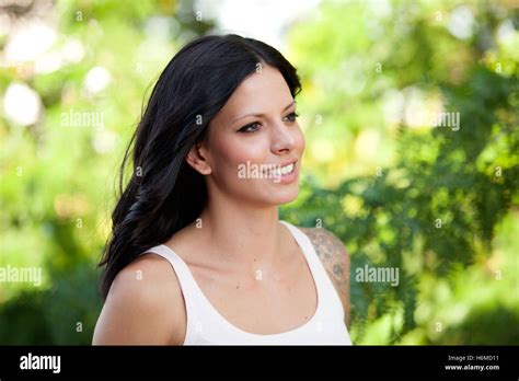 Beautiful Brunette Girl Relaxing In The Park Wiht Many Plants Of