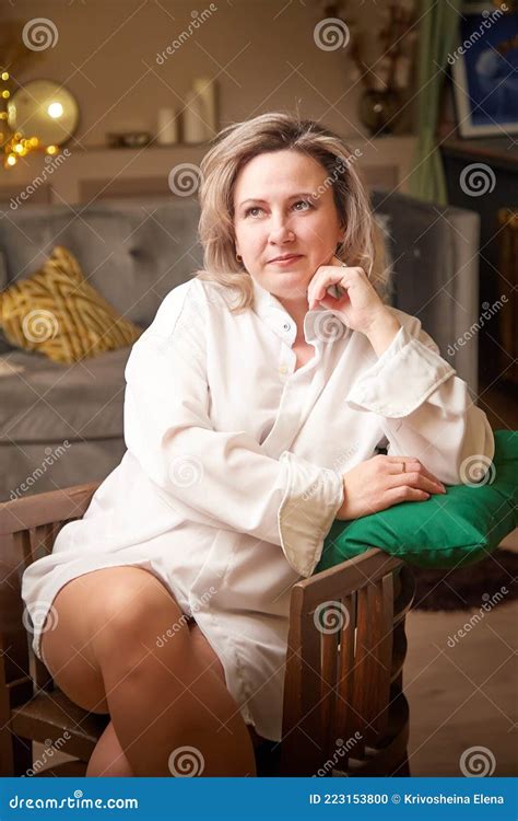 A Plump Pretty Middle Aged Woman With Blonde Hair Resting In A Room By Herself Stock Photo