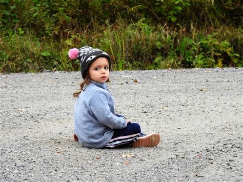 Premium Photo Innocent Girl Sitting On Ground