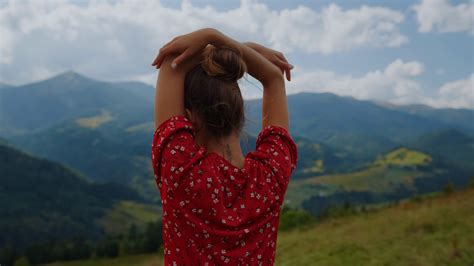 Back View Of Unknown Tranquil Woman Standing In Front Mountains Scenery