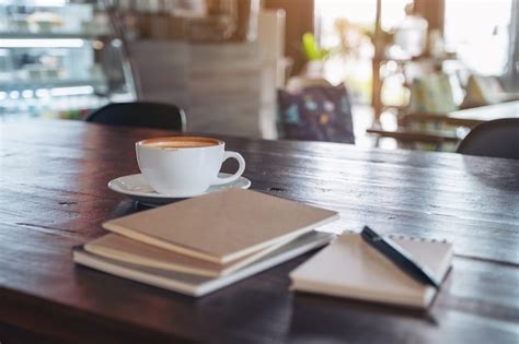 Premium Photo Notebooks Pen And Coffee Cup On Wooden Table