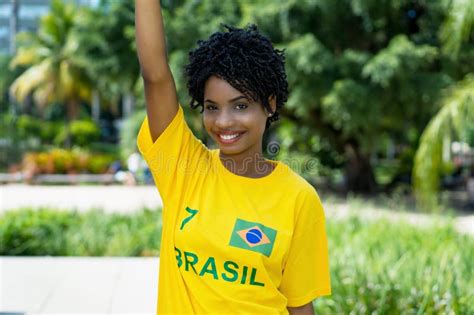 Cheering Young Woman From Brazil With Yellow Football Jersey Stock