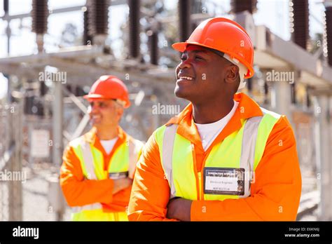 Smiling African Electrical Engineer In Substation With Colleague On