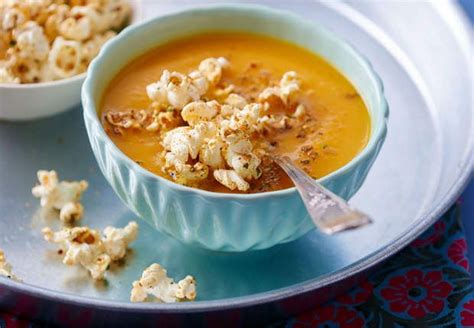 Two Bowls Filled With Soup And Popcorn On A Silver Plate Next To