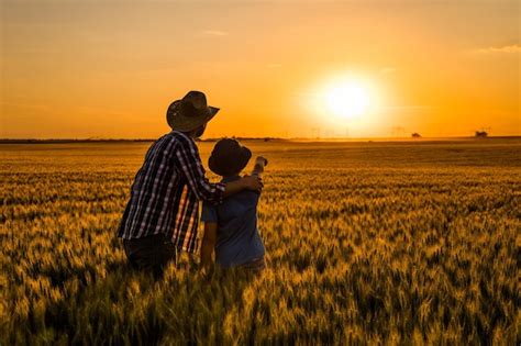 Premium Photo Father And Son Are Standing In Their Growing Wheat Field