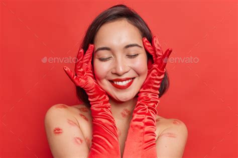 Headshot Of Positive Asian Woman Touches Face Gently Has Healthy Skin Wears Red Lipstick Keeps