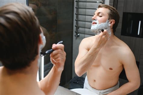 Premium Photo Mature Handsome Man Shaving In Front Of Mirror