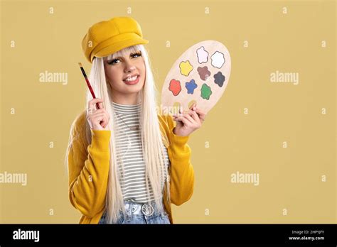 Blonde Spanish Woman With Cap And Paint Palette On A Yellow Background