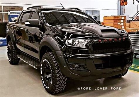 A Large Black Truck Parked In A Garage